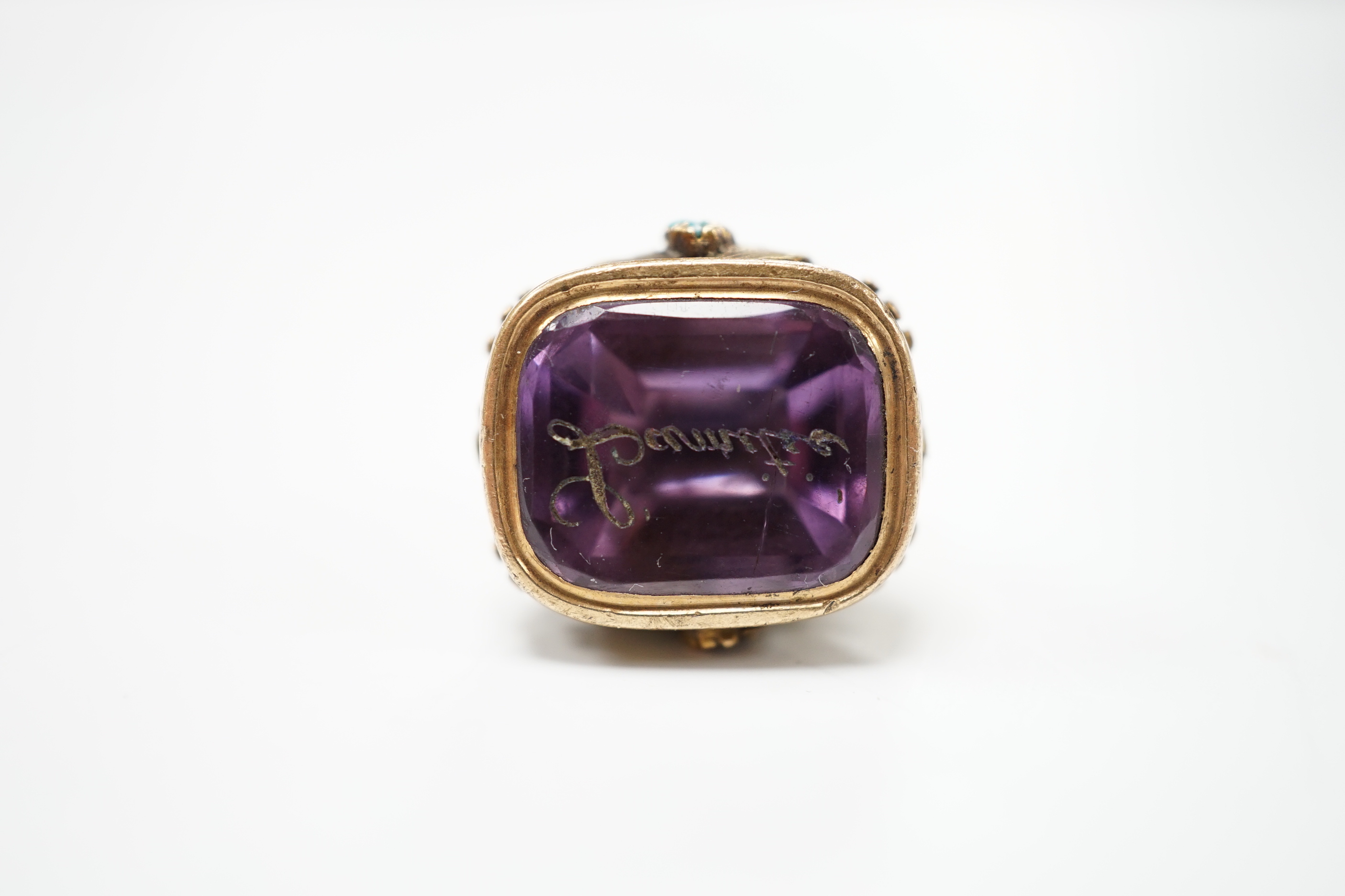 A 19th century yellow metal, garnet and turquoise mounted foil backed amethyst fob seal, the matrix inscribed Lamitie?, 17mm (a.f.).